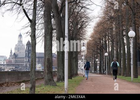 02 janvier 2023, Saxe, Dresde: Les passants longent une avenue en toile de fond de la vieille ville avec la Frauenkirche. La nouvelle année en Saxe commence par des températures exceptionnellement douces. Selon le Service météorologique allemand de Leipzig, il restera nuageux lundi à 14 à 17 degrés Celsius, mais largement exempt de précipitations. Il y a un vent frais, sur le Fichtelberg, la plus haute montagne de Saxe avec environ 1215 mètres, même avec des calmars. Photo: Sebastian Kahnert/dpa Banque D'Images
