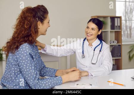 Joyeux sourire médecin de soutien rassurant sa patiente pendant la consultation médicale Banque D'Images