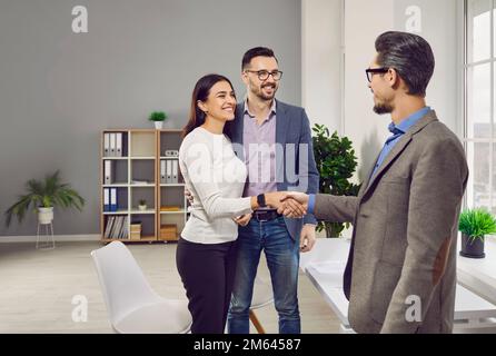 Un jeune couple heureux rencontre avec le directeur de banque, un avocat, un agent immobilier, un assureur Banque D'Images