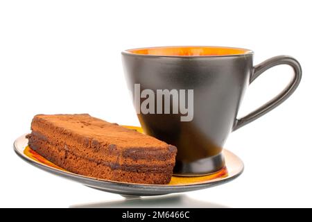 Un morceau de gâteau à la truffe sur une soucoupe en céramique avec une tasse noire, macro, isolée sur fond blanc. Banque D'Images