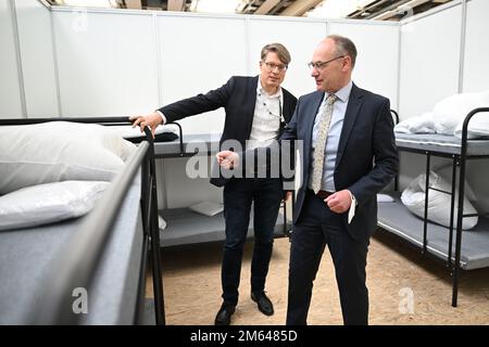 Friedrichshafen, Allemagne. 02nd janvier 2023. Lothar Wölfle (r, CDU), administrateur de district du district de Constance, et chef des affaires sociales, Ignaz Wetzel, regardent une aire de vie dans un refuge d'urgence après avoir expliqué le concept d'accueil du district. La salle de sport de l'école professionnelle de Friedrichshafen a été transformée en hébergement d'urgence pour les réfugiés. Jusqu'à 240 personnes peuvent être hébergées. Credit: Felix Kästle/dpa/Alay Live News Banque D'Images