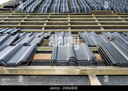 Carreaux de céramique de toit disposés en paquets sur le toit sur les lattes de toit. Préparation pour la pose de carreaux sur un toit à boaron. Banque D'Images
