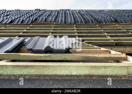 Carreaux de céramique de toit disposés en paquets sur le toit sur les lattes de toit. Préparation pour la pose de carreaux sur un toit à boaron. Banque D'Images