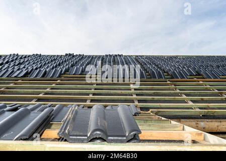 Carreaux de céramique de toit disposés en paquets sur le toit sur les lattes de toit. Préparation pour la pose de carreaux sur un toit à boaron. Banque D'Images
