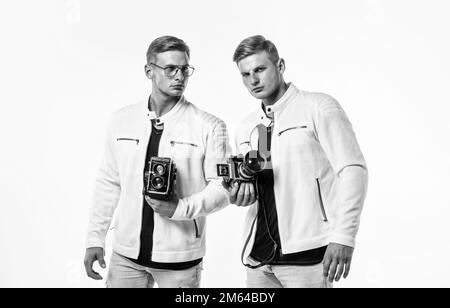 les deux frères hommes se ressemblent utilisent un appareil photo vintage pour photographier Banque D'Images
