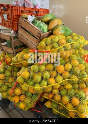 Sacs en maille jaune d'oranges pillés sur le chariot avec une caisse de papaye Banque D'Images