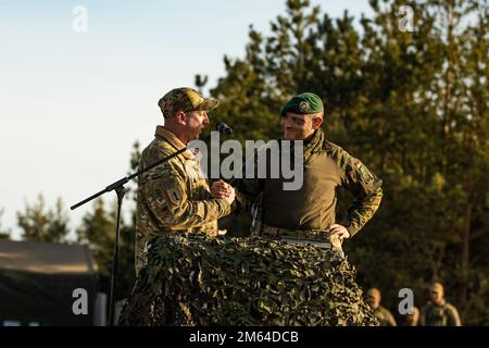 Le lieutenant-colonel Daniel Andrä, commandant du bataillon de la présence avancée renforcée de l'OTAN en Lituanie, Et le lieutenant-colonel Paul Godson, commandant du 3rd Bataillon, 66th Armored Regiment, 1st Infantry Division, se saluent lors d'une exposition statique tenue pour commencer l'exercice Rising Griffin à la zone d'entraînement de Pabrade, Lituanie, 31 mars 2022. Les membres de l'Alliance de l'Atlantique Nord qui ont participé à l'événement ont présenté certaines de leurs capacités de protection de la force pour rassurer leurs alliés de leur dévouement envers leur défense commune. Banque D'Images