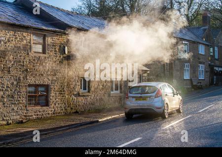 Limbrick, Lancashire. Météo Royaume-Uni. -3 C dans le nord-ouest comme le soleil bas tôt le matin met en évidence les émissions de vapeur de chauffage central de la propriété résidentielle de long Lane. Les chaudières produisent de longs panaches de vapeur avec l'humidité de l'air qui jouent également un rôle important dans les processus de condensation. Les gaz de combustion entrent en contact avec l'air humide froid, puis commencent à produire de longs panaches de minuscules gouttelettes d'eau. Crédit : MediaWorldImages/AlamyLiveNews Banque D'Images