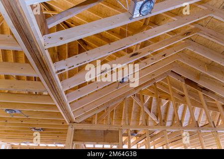 Installation système d'éclairage de lampe de spot dans la nouvelle construction de maison en le montant au plafond en installant le cadre de poutre en bois Banque D'Images