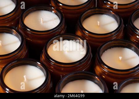 Groupe de bougies de cire de noix de coco de soja faites à la main dans un récipient ambré et opaque, pot en verre brun. Bougies de cire bio écologiques et naturelles. Concept tendance Banque D'Images