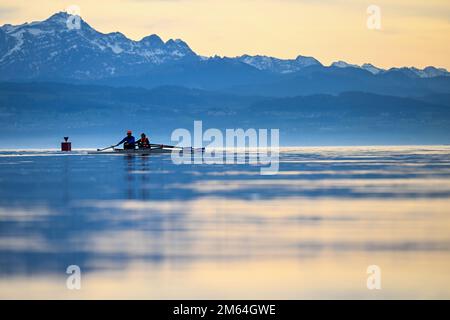 Friedrichshafen, Allemagne. 02nd janvier 2023. Deux rameurs traversent le lac de Constance tandis que les Alpes suisses sont visibles en arrière-plan. Le Säntis est visible sur la gauche. Credit: Felix Kästle/dpa/Alay Live News Banque D'Images