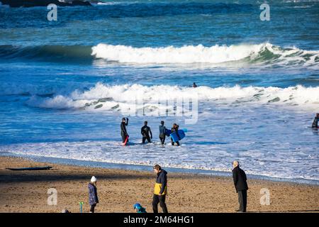 Portreath,Cornouailles,2nd janvier 2023,Surfers dans la mer à marée haute à Portreath,Cornouailles. Le ciel était bleu avec le soleil glorieux et 8C, la prévision après aujourd'hui est pour le temps humide pour les prochains jours. Le pétrolier Maersk Bering a été ancré juste au large de la côte, ce qui est très inhabituel.Credit: Keith Larby/Alamy Live News Banque D'Images