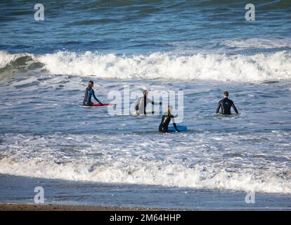 Portreath,Cornouailles,2nd janvier 2023,Surfers dans la mer à marée haute à Portreath,Cornouailles. Le ciel était bleu avec le soleil glorieux et 8C, la prévision après aujourd'hui est pour le temps humide pour les prochains jours. Le pétrolier Maersk Bering a été ancré juste au large de la côte, ce qui est très inhabituel.Credit: Keith Larby/Alamy Live News Banque D'Images