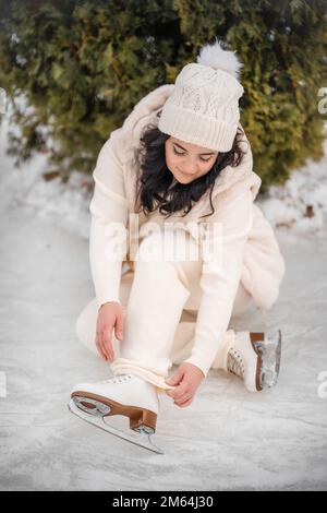 Belle fille s'amuser et mettre sur des patins à glace sur fond d'arbre de noël, Prague, République Tchèque Banque D'Images