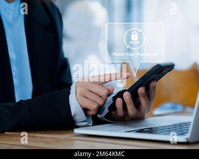 Concept de réinitialisation du mot de passe. Icône de verrouillage, code de sécurité apparaissant sur le téléphone mobile intelligent entre les mains d'un professionnel tout en travaillant avec un ordinateur portable en toute sécurité Banque D'Images