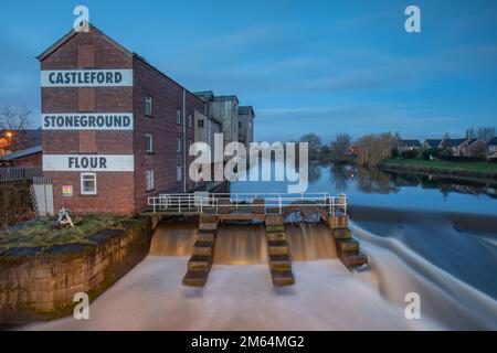 Castleford, la rivière aire dans le West Yorkshire, dans le nord de l'Angleterre. avec l'ancien moulin à pierre et le déversoir. Banque D'Images