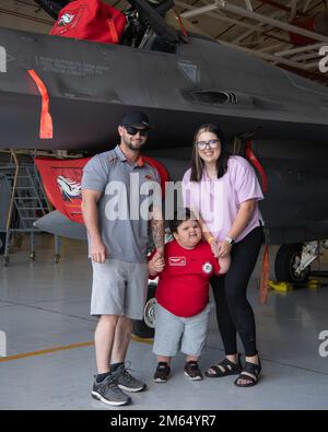 Grayson 'Blazin' Anthony, pilote de l'aile 138th pour une journée, et sa famille se tiennent devant un F-16 Viper 2 avril 2022 à la base aérienne de la Garde nationale de Tulsa, en Oklahoma. Dans le cadre du programme pilote pour Une journée, Grayson et sa famille ont visité le hangar et ont obtenu une vue rapprochée des avions. Banque D'Images