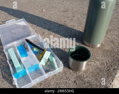 Kit de pêche et tasse à café et thermos. Concept d'équipement de pêche et de boisson chaude. Banque D'Images