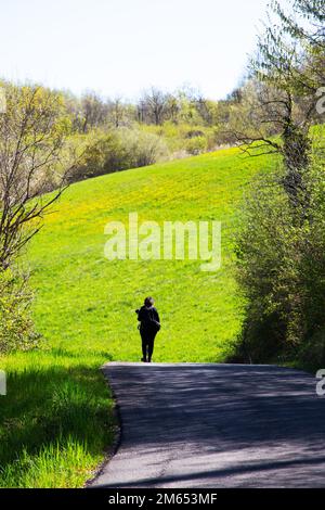 Une femme se déplace sur une route à flanc de colline Banque D'Images