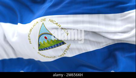 Vue rapprochée du drapeau national du Nicaragua qui agite. Il est bleu, blanc et bleu avec un blason national et. Arrière-plan texturé en tissu. Sélection Banque D'Images