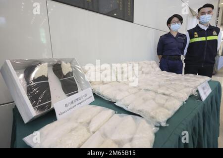 (À gauche) Lau TSZ-Yan, inspecteur principal (unité d'examen du fret conteneurisé) 2, et Jacky Yau Wing-Yeung, enquêteur, Division d'enquête sur les drogues 3, Bureau d'enquête sur les drogues des douanes de Hong Kong les douanes et l'accise tiennent un agent de contrôle sur l'arrestation d'un homme en rapport avec la saisie de cocaïne présumée d'un poids de 31kg et portant une valeur marchande estimée de 26m 000 $ au siège des douanes de North point. 28DEC22 SCMP / Jelly TSE Banque D'Images