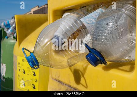 Gros plan d'une poubelle de recyclage en plastique jaune remplie de récipients en plastique vides Banque D'Images