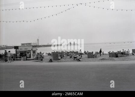 1950s, historique, les gens à la plage de North Bay sur Scarborough, une station balnéaire dans East Yorkshire, Angleterre, Royaume-Uni. Un kiosque, « Beach Pictures », propose des photos sur la plage produites par photo Casino Ltd de Scarborough & Clayton Bay. La ville côtière est devenu une destination balnéaire importante et de nombreux studios photographiques ont été mis en place pour fournir des photos de vacances aux visiteurs, y compris après la Seconde Guerre mondiale, photo Casino Co Ltd Banque D'Images