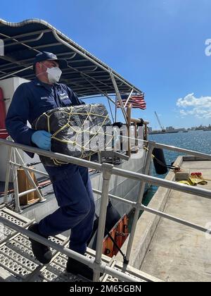 Un membre d'équipage de la Garde côtière, Donald Horsley, aide à décharger environ 1 000 kilogrammes de cocaïne saisie, d'une valeur de $20 millions de dollars, à la base de la Garde côtière de San Juan 4 avril 2022, suite à l'interdiction d'un navire à grande vitesse dans le 30 mars 2022 de la mer des Caraïbes près de Porto Rico. Administration de l'application de la loi sur les drogues les agents spéciaux ont reçu la garde de deux contrebandiers présumés et de la contrebande saisie. Cette interdiction est le résultat d'efforts multi-agences impliquant le Groupe d'agences frontalières des Caraïbes et la Force de frappe du corridor des Caraïbes. (É.-U. Photo de la Garde côtière) Banque D'Images