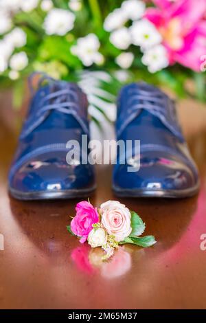 Petit bouquet de fleurs près des vêtements de mariage d'homme. Banque D'Images