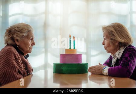 deux sœurs âgées, bavardant tranquillement au-dessus d'une table en bois dans une maison de repos. concept de famille et de vieillesse. Banque D'Images