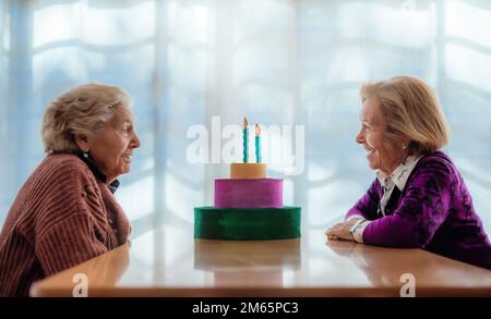 deux sœurs âgées, bavardant avec joie sur une table en bois dans une maison de personnes âgées. concept de famille et de vieillesse. Banque D'Images