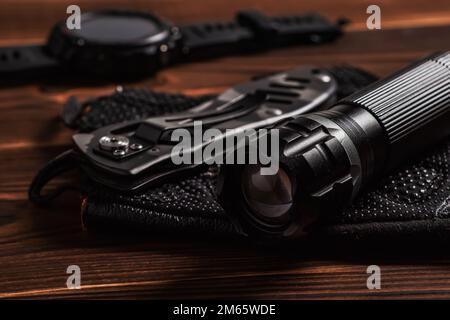 Articles EDC de transport quotidien pour hommes de couleur noire : lampe de poche, montre et couteau. Ensemble de survie. Concept minimal Banque D'Images