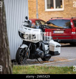 Göteborg, Suède - 03 octobre 2022 : moto Challenger indienne blanche garée par un hangar bleu Banque D'Images