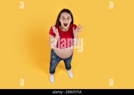 Portrait de la jeune femme enceinte choquée ouverture de la bouche dans l'étonnement Banque D'Images