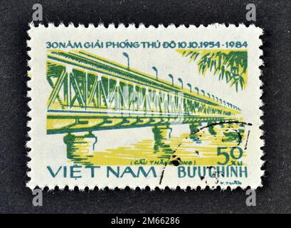 Timbre-poste annulé imprimé par le Vietnam, qui montre Thang long Bridge, libération de Hanoi, 30th anniversaire, vers 1984. Banque D'Images