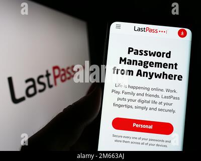 Personne tenant un téléphone cellulaire avec le site Web de la société de gestion de mot de passe LastPass US LP à l'écran devant le logo. Concentrez-vous sur le centre de l'écran du téléphone. Banque D'Images