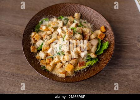 Salade César délicieuse, fraîche, juteuse et saine prête à manger avec poulet, croûtons de pain, feuilles de salade, laitue sur l'assiette Banque D'Images