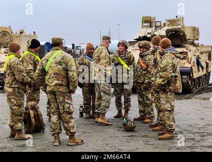 ESBJERG, DANEMARK (6 avril 2022) général de division Robert Burke, commandant général adjoint du soutien, États-Unis Le corps de l'armée V, au centre, s'engage avec des soldats qui aident à décharger des véhicules militaires d'un navire de transit. Dans le cadre d'une démonstration d'interopérabilité avec les alliés de l'OTAN, l'envoi a été organisé par l'armée britannique et déchargé dans un port danois. V corps est le Forward Deployed corps de l'Amérique en Europe et travaille aux côtés des alliés de l'OTAN et des partenaires de sécurité régionaux pour fournir des forces prêtes au combat, exécuter des exercices d'entraînement conjoints et multinationaux, et conserver le commandement et le contrôle de tous les rota Banque D'Images