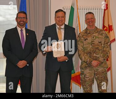 Michael S. Amarosa, USAG Rheinland Pfalz Commandant adjoint de la garnison, et Sgt. Maj. Stephen J. LaRocque, présente un prix pour la durée du service à Jason S. Tudor, chef adjoint des affaires publiques, pour avoir atteint l'année de service 35. La cérémonie de remise des prix de la durée du service civil a eu lieu au club Rheinlander de Baumholder, en Allemagne, à 06 avril 2022. Banque D'Images