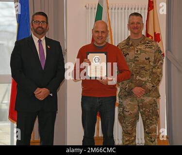 Michael S. Amarosa, USAG Rheinland Pfalz Commandant adjoint de la garnison, et Sgt. Maj. Stephen J. LaRocque, présente un prix de durée de service à Stefan Schupp, ingénieur mécanique, pour avoir obtenu 20 ans de service. La cérémonie de remise des prix de la durée du service civil a eu lieu au club Rheinlander de Baumholder, en Allemagne, à 06 avril 2022. Banque D'Images