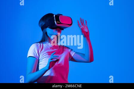 Brunette femme architecte ou ingénieur portant un casque VR pour la conception de travail modèle architectural 3D dans l'espace de réalité virtuelle. Banque D'Images