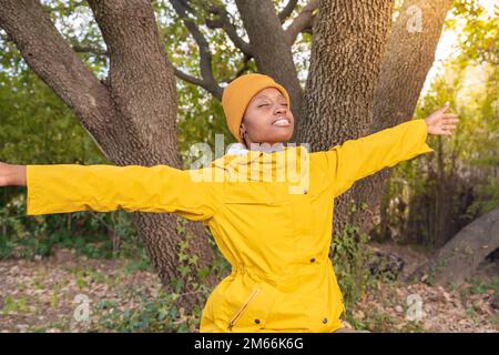 Femme randonneur en imperméable jaune avec ses mains sur un voyage en montagne à l'automne. Concept de liberté Banque D'Images
