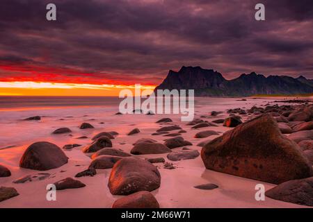 Coucher de soleil spectaculaire à minuit avec des couleurs étonnantes sur la plage d'Uttakleiv sur les îles Lofoten, Norvège Banque D'Images