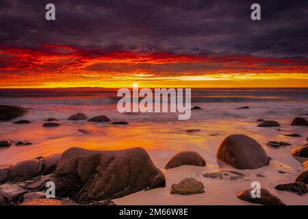 Coucher de soleil spectaculaire à minuit avec des couleurs étonnantes sur la plage d'Uttakleiv sur les îles Lofoten, Norvège Banque D'Images