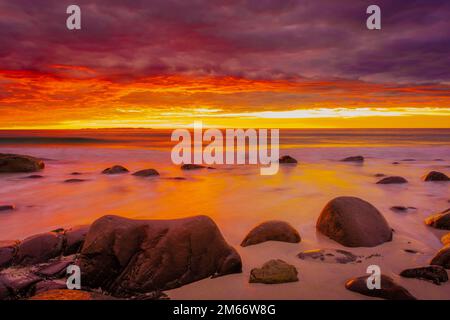 Coucher de soleil spectaculaire à minuit avec des couleurs étonnantes sur la plage d'Uttakleiv sur les îles Lofoten, Norvège Banque D'Images