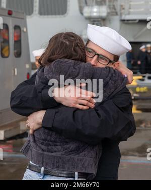 Un Sailor se réunit avec sa famille après l'arrivée du destroyer de missiles guidés de classe Arleigh Burke USS McCampbell (DDG 85) à son nouveau port d'attache de la base navale d'Everett, Washington 8 avril 2022. Avant de déménager, le navire a subi une longue période de modernisation du dépôt à Portland, Oregon, qui a duré plus de 18 mois. La modernisation comprenait des améliorations à la coque, aux systèmes mécaniques, à la technologie électrique, aux communications sans fil et à la modernisation des armes. Cette maintenance de routine permet au navire de continuer à être en mesure de fonctionner pendant toute sa durée de vie prévue. Banque D'Images