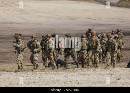 Les parachutistes américains et les soldats polonais marchent ensemble après avoir mené un exercice de tir en direct conjoint combiné à Nowa Deba, 8 avril. L'équipe de combat de 3rd Brigade, 82nd Airborne Division, est déployée à l'appui des États-Unis Commandement européen pour assurer nos alliés et dissuader toute agression future. Banque D'Images