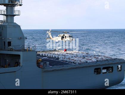 Un MH-60S Nighthawk, attaché aux « Tridents » du Helicopter Sea combat Squadron (HSC) 9, se prépare à transporter des munitions vers l'USS Gerald R. Ford (CVN 78) lors d'un chargement de munitions avec l'USNS William McLean (T-AKE 12), le 9 avril 2022. Ford est en cours dans l'océan Atlantique pour la qualification des transporteurs et l'intégration des groupes de grève avant le déploiement opérationnel. GRF, Navy, US Navy, USS Gerald R. Ford (CVN 78), Banque D'Images