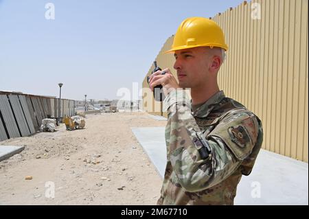 Airman classe 1st Kalani Hughes, 386th Expeditionary civil Engineer Squadron Force protection membre de l'avion fournit une mise à jour de statut tout en observant les entrepreneurs construire un complément au Flex Gym à la base aérienne Ali Al Salem, 5 avril, 2022. Le vol de protection de la force ECES 386 aide à maintenir la sécurité de niveau de base en comptabilisant et escortant avec précision les ressortissants d'autres pays (ONC) vers et depuis divers sites de travail tout au long de l'installation et en assurant leur départ de la base à la fin de la journée. Banque D'Images