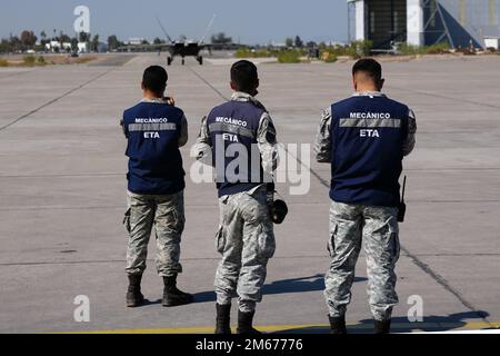 Les membres de l’équipe de terrain de la Force aérienne chilienne regardent un F-22 de l’équipe de démonstration F-22 Raptor en taxi vers la piste pour décoller et effectuer sa routine de vol à grande vitesse à Feria Internacional del aire y del Espacio (FIDAE), la plus grande exposition aérospatiale, défense et sécurité d’Amérique latine, à Santiago, au Chili, au 8 avril 2022. L'équipe de démonstration F-22 représente les États-Unis Air Force aux salons aériens du monde entier, et sont sélectionnés sur la base de compétences, d'interdiction militaire et de mérite personnel et professionnel. (Photo de la Force aérienne par le Sgt. Michael Davis) Banque D'Images